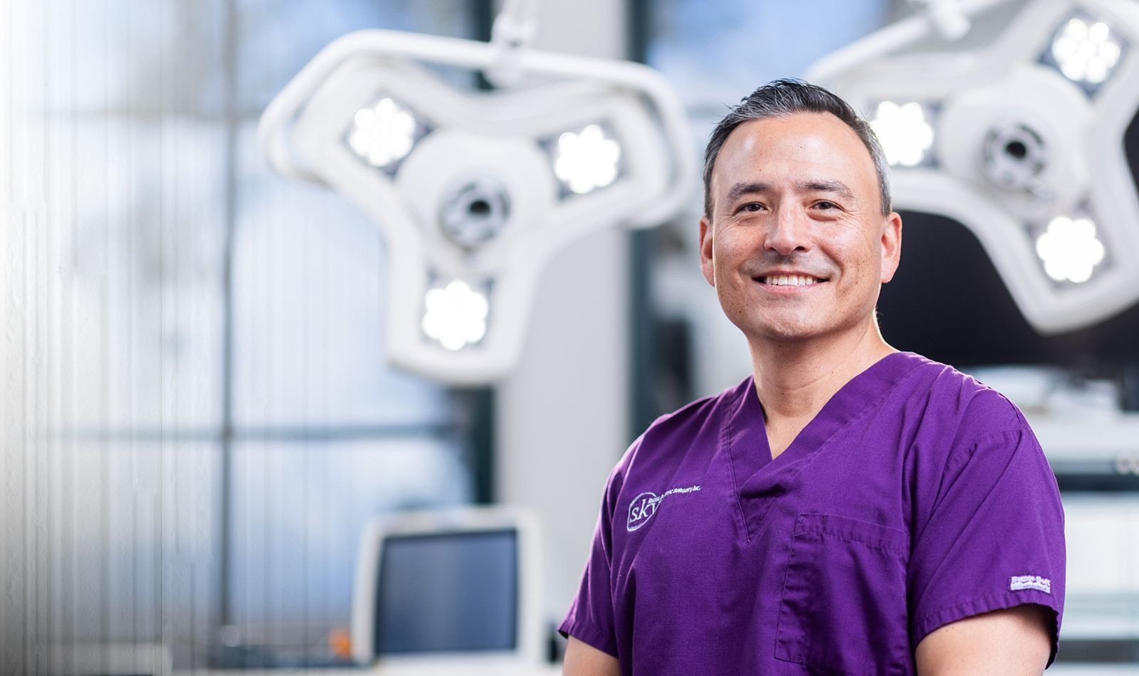 Smiling medical professional in surgical environment.