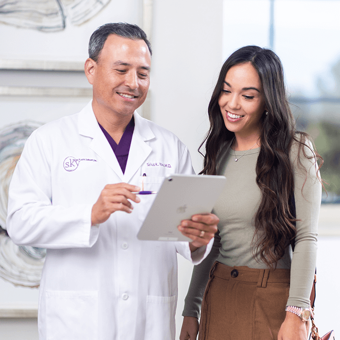 Doctor consulting with a patient using a tablet.