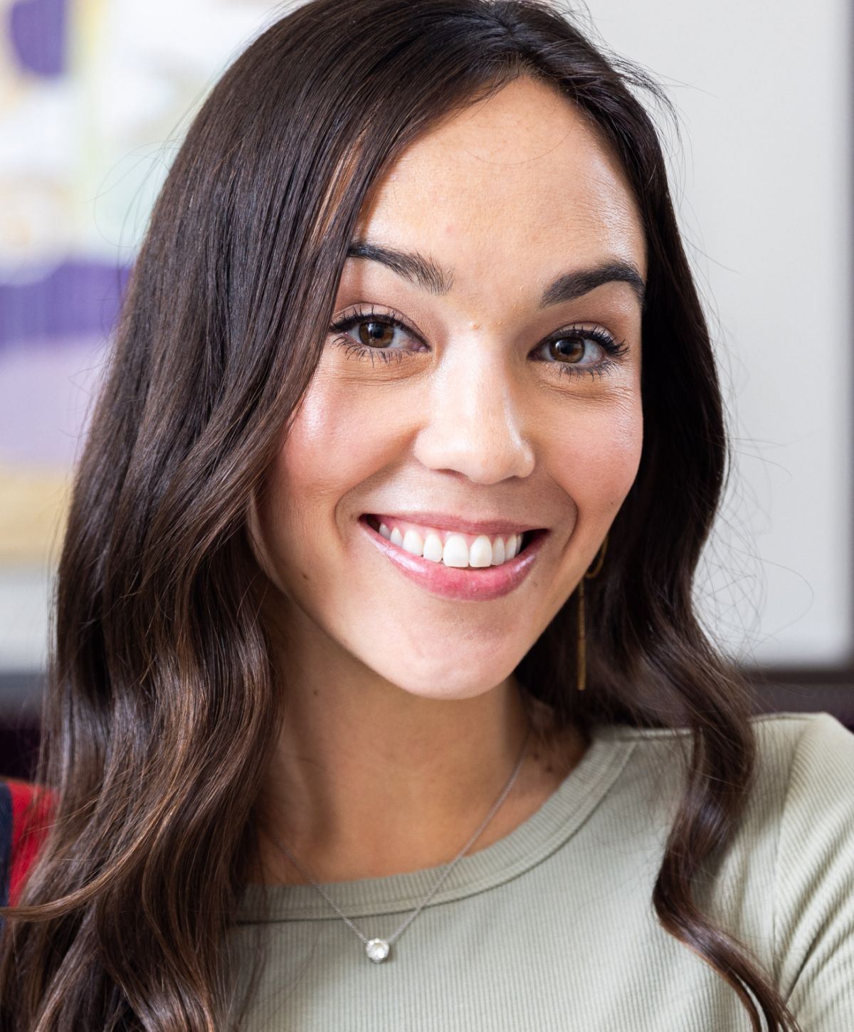 Smiling woman with long hair and necklace.