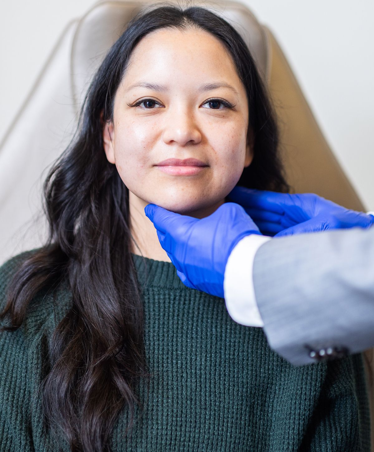 Woman in consultation with gloved practitioner.