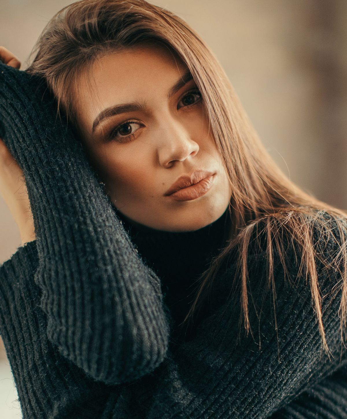 Woman in black sweater, thoughtful expression.